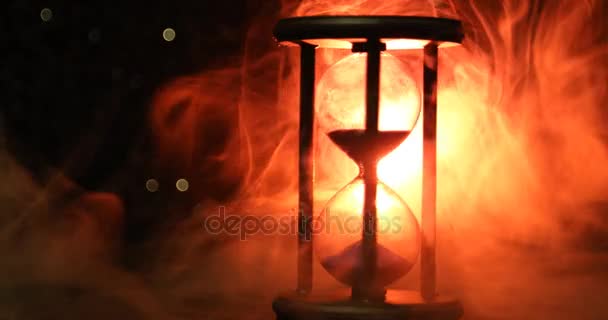 時間の概念 暗いトーンの背景 または煙 最後の下の時間のシンボルに煙で回転砂時計時計のシルエット — ストック動画