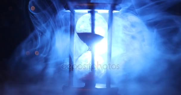 时间概念 在黑暗的色调背景下 在烟雾中旋转的沙漏时钟剪影 或在烟雾下的时间符号 — 图库视频影像