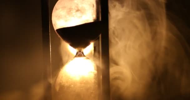 时间概念 在黑暗的色调背景下 在烟雾中旋转的沙漏时钟剪影 或在烟雾下的时间符号 — 图库视频影像