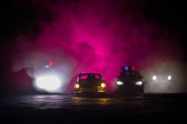 Sis arka plan ile gece bir Ford Thunderbird araba kovalayan oyuncak Bmw polis ve Toyota Fj Cruiser arabalar. Oyuncak dekorasyon sahne masada. - 11 Ocak 2018, Bakü Azerbaycan