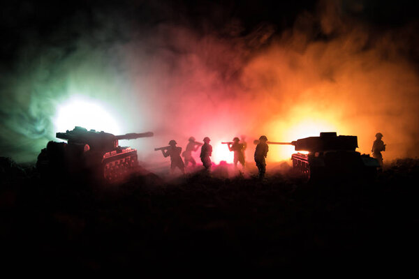 War Concept. Military silhouettes fighting scene on war fog sky background, World War Soldiers Silhouettes Below Cloudy Skyline At night. Attack scene. Armored vehicles. Tanks battle.
