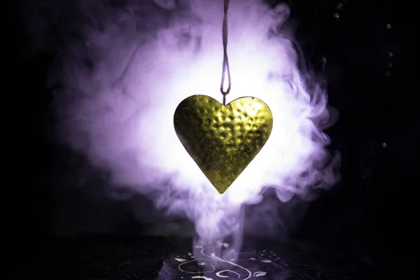 Золоте серце висить на мотузку на темні тоновані димний фон і простір для тексту. Валентина день концепції. — стокове фото