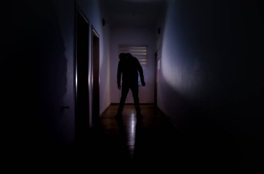 Kabine kapılar ve korkunç korku adam ile farklı pozlar ayakta silüeti ışıklarla karanlık koridor.