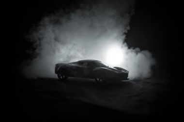 Gölgelerin içinde araba ile düşük ışık veya spor araba koyu arka plan silüeti parlayan ışıklar