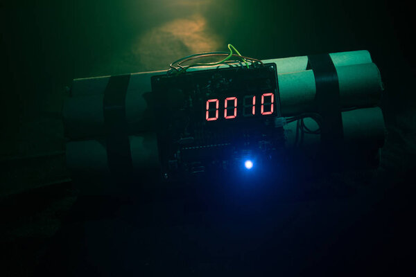 Изображение бомбы замедленного действия на темном фоне. Таймер отсчитывает время до детонации, освещаемой светом шахты, сияющим сквозь темноту.
