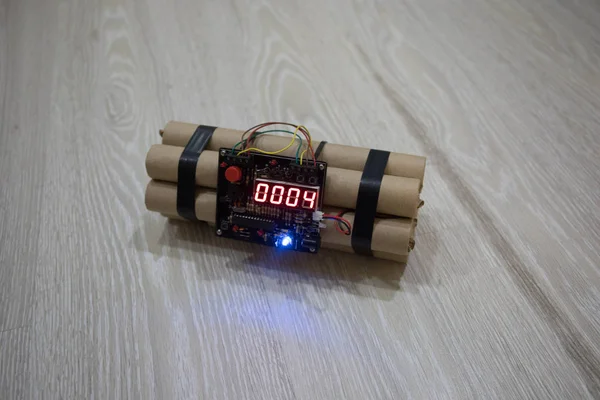 Image of a time bomb on floor. Timer counting down to detonation illuminated in a shaft light shining through the darkness