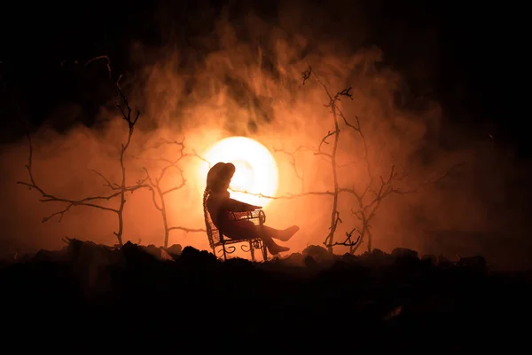 Sziluettjét lány ül a swing, a ködös narancssárga háttere lett. Szelektív összpontosít. — Stock Fotó