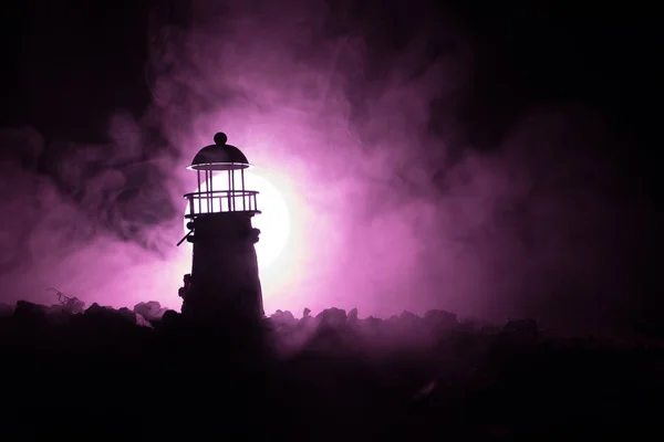 Farol com feixe de luz à noite com nevoeiro . — Fotografia de Stock