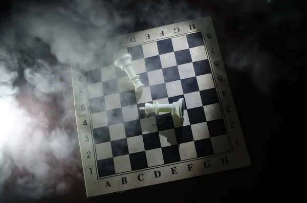 Chess board game concept of business ideas and competition and strategy ideas concep. Chess figures on a dark background with smoke and fog. — Stock Photo, Image