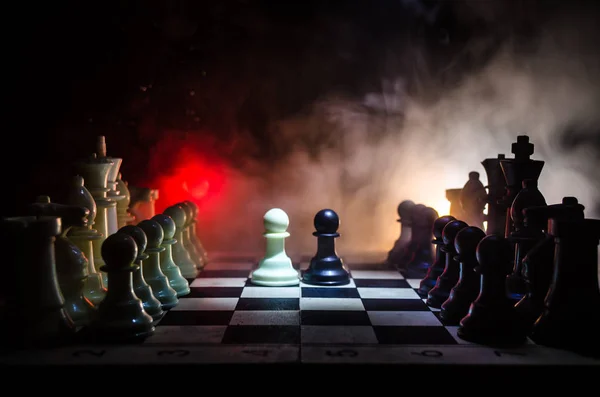 Концепция шахматной настольной игры бизнес-идей, конкуренции и стратегических идей. Шахматные фигуры на темном фоне с дымом и туманом . — стоковое фото