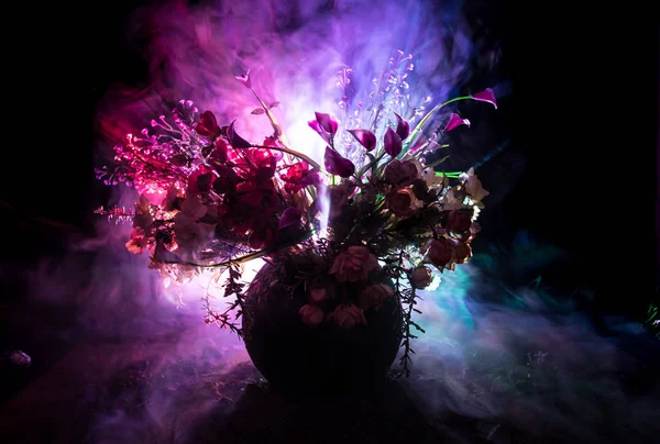 Picturesque purple spring flowers in glass vase standing in a row on a dark background with stars with light and fog. Flower concept. — Stock Photo, Image