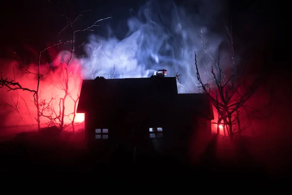 Altes Haus mit einem Geist im nächtlichen Wald oder verlassenes Gruselhaus im Nebel. altes mystisches Gebäude im toten Baumwald. — Stockfoto