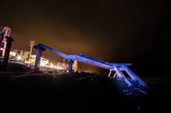 Frammento del vecchio ponte conrete vicino al mare di Nabran. A nord dell'Azerbaigian. Mar Caspio di notte con freezelight su di esso con colori diversi. Vista da sotto il ponte. Focus selettivo — Foto Stock