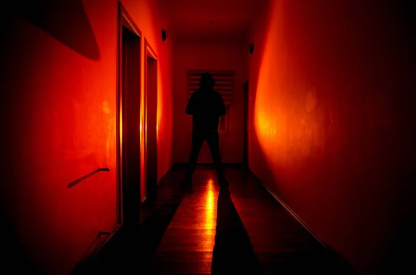 Corredor oscuro con puertas de gabinete y luces con silueta de espeluznante hombre de horror de pie con diferentes poses . — Foto de Stock