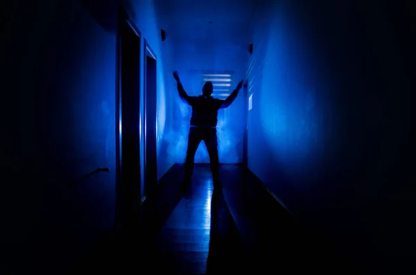 キャビネットの扉や不気味なホラーに異なるポーズで立っている男のシルエットが付いているライトで暗い廊下. — ストック写真
