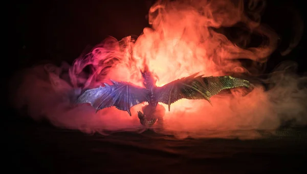 Silueta de fuego respirando dragón con grandes alas sobre un fondo naranja oscuro. Imagen de horror —  Fotos de Stock