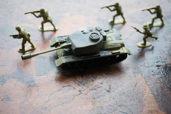 miniature toy soldiers and tank on board. Close up image of toy military at war.
