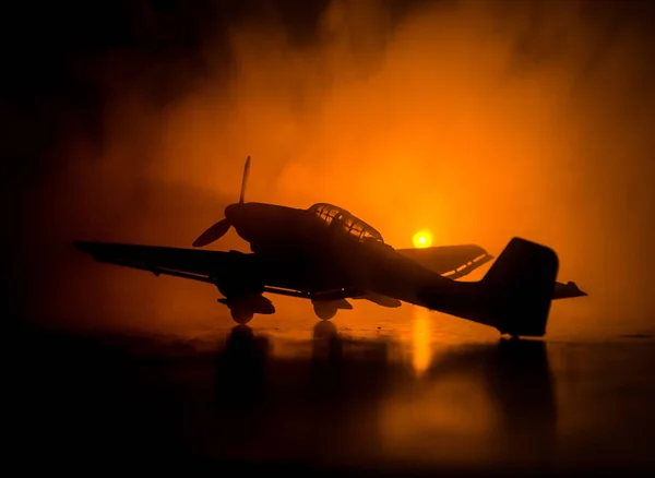 Junker Německo (Ju-87) čluny model letadla v držení. Na pozadí tmavě oranžový oheň. Válečné scény. Selektivní fokus (rozdíl pozice umístění) — Stock fotografie