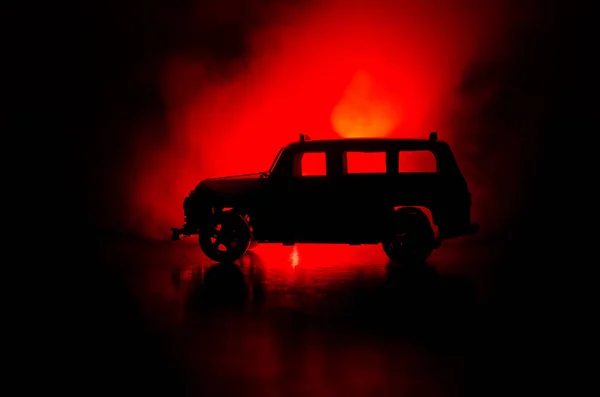 Bilen i skuggorna med glödande lampor i svagt ljus eller silhuetten av sport bil mörk bakgrund. — Stockfoto