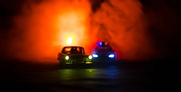 Juguete BMW Coche de policía persiguiendo un coche Ford Thunderbird en la noche con fondo de niebla. Escena de decoración de juguete en la mesa. Enfoque selectivo - 11 ENE 2018, BAKU AZERBAIJAN —  Fotos de Stock