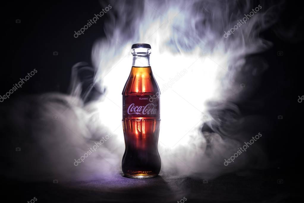 Baku, Azerbaijan 13th January 2018, Coca-Cola Classic in a glass bottle on dark toned foggy Background. Coca Cola, Coke is the most popular carbonated soft drink beverages sold around the world