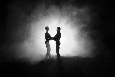 Aşk Sevgililer günü kavramı. Tatlı genç çift alanında duran ve üzerinde koyu tonda sisli arka plan sarılma aşık Sillhouette. Dekorasyon bebek ile vurdu masaya rakamlar.