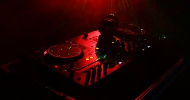 DJ iplik, karıştırma ve tırmalamak dj elinde bir gece kulübünde dj's güverte, strobe ışıklar ve sis, seçici odak çeşitli parça denetimlere tweak, yakın çekim
