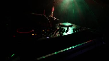 DJ iplik, karıştırma ve tırmalamak dj elinde bir gece kulübünde dj's güverte, strobe ışıklar ve sis, seçici odak çeşitli parça denetimlere tweak, yakın çekim