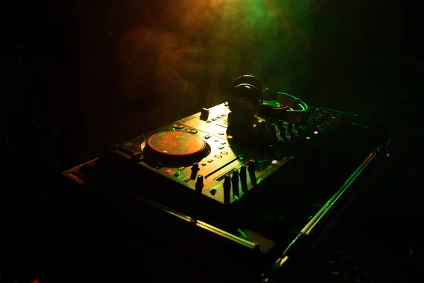 DJ Spinning, Mixing, and Scratching in a Night Club, Manos de dj ajustar varios controles de pista en la cubierta de dj, luces estroboscópicas y niebla, o Dj mezcla la pista en el club nocturno en la fiesta —  Fotos de Stock