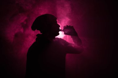 Bir mod tutarak Vaping adam. Buhar bulutu. Siyah arka plan. Vaping elektronik sigara duman bir sürü ile. Vape kavramı