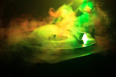 Pikap vinil plak çalar. Retro ses ekipmanları için disk jokey. Dj mix ve müzik çalmak için ses teknolojisi. Yangın arka plan yanan karşı oynanan vinil kaydı