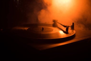 Pikap vinil plak çalar. Retro ses ekipmanları için disk jokey. Dj mix ve müzik çalmak için ses teknolojisi. Yangın arka plan yanan karşı oynanan vinil kaydı