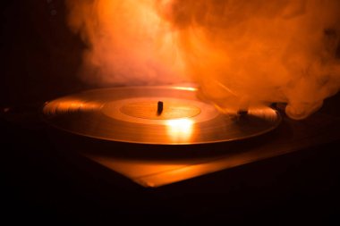 Pikap vinil plak çalar. Retro ses ekipmanları için disk jokey. Dj mix ve müzik çalmak için ses teknolojisi. Yangın arka plan yanan karşı oynanan vinil kaydı