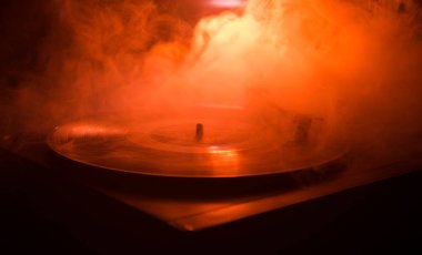 Pikap vinil plak çalar. Retro ses ekipmanları için disk jokey. Dj mix ve müzik çalmak için ses teknolojisi. Yangın arka plan yanan karşı oynanan vinil kaydı