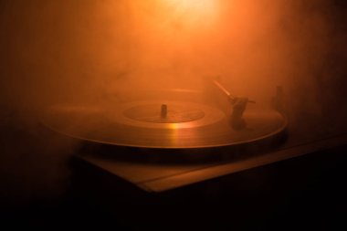 Pikap vinil plak çalar. Retro ses ekipmanları için disk jokey. Dj mix ve müzik çalmak için ses teknolojisi. Yangın arka plan yanan karşı oynanan vinil kaydı