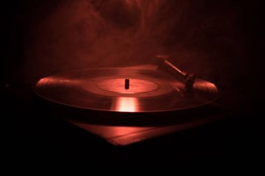 Pikap vinil plak çalar. Retro ses ekipmanları için disk jokey. Dj mix ve müzik çalmak için ses teknolojisi. Yangın arka plan yanan karşı oynanan vinil kaydı