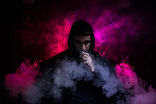 Vaping pria memegang mod. Awan Uap. Latar belakang hitam Menguap rokok elektronik dengan banyak asap. Konsep Vape — Stok Foto