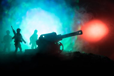 Arillery ve ayakta asker ile savaş sahnesi. Eski Sahra Topu ayakta alanı ateşe hazır, silüeti. Renkli karanlık sisli arka plan ile.