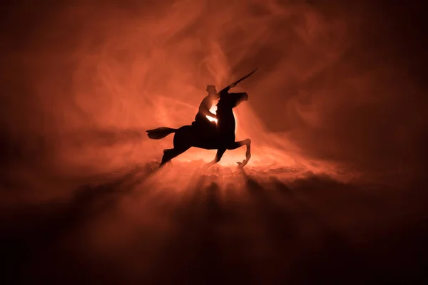 Ufficiale di guerra mondiale (o guerriero) cavaliere a cavallo con una spada pronta a combattere e soldati su uno sfondo scuro nebbioso tonica. Scena di battaglia campo di battaglia di soldati combattenti. Scena di guerra . — Foto Stock