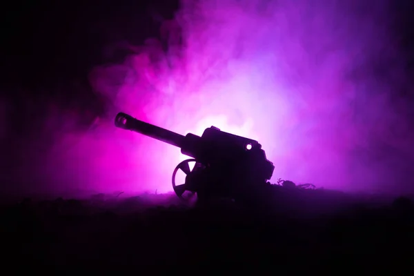 Battle scene. Silhouette of old field gun standing at field ready to fire. With colorful dark foggy background — Stock Photo, Image