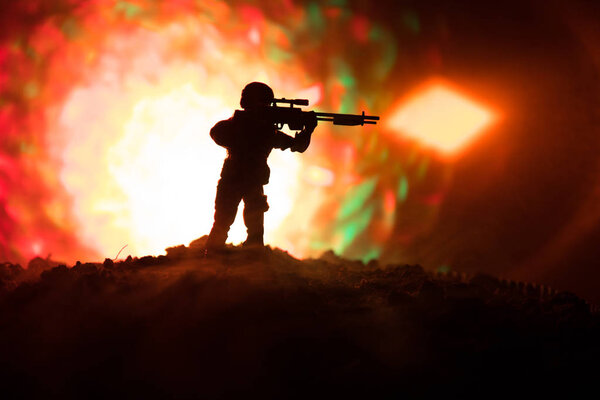 Армейский снайпер с крупнокалиберной снайперской винтовкой ищет убийцу врага. Силуэт на фоне неба. Национальная безопасность обеспечена, военнослужащие на страже
