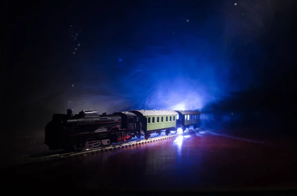 Zug bewegt sich im Nebel. Alte Dampflokomotive in der Nacht. Nachtzug fährt auf der Eisenbahn. orangefarbener Hintergrund. — Stockfoto