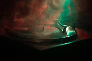 Pikap vinil plak çalar. Retro ses ekipmanları için disk jokey. Dj mix ve müzik çalmak için ses teknolojisi. Yangın arka plan yanan karşı oynanan vinil kaydı