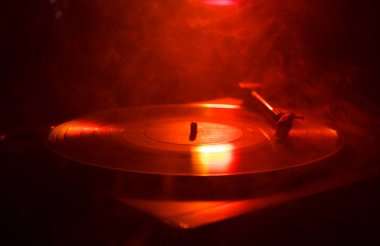 Pikap vinil plak çalar. Retro ses ekipmanları için disk jokey. Dj mix ve müzik çalmak için ses teknolojisi. Yangın arka plan yanan karşı oynanan vinil kaydı