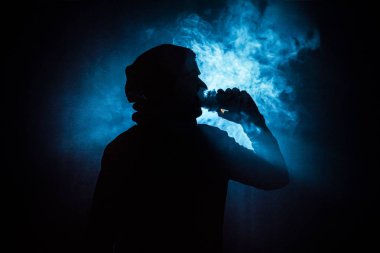 Bir mod tutarak Vaping adam. Buhar bulutu. Siyah arka plan. Vaping elektronik sigara duman bir sürü ile. Vape kavramı