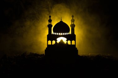 Cami binasında silüeti sisli arka plan tonda. Ramazan Kareem arka plan. Gün batımında Camii. İnsanlar dua. Seçici odak