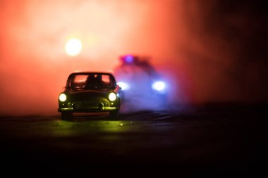 Sis arka plan ile gece bir Ford Thunderbird araba kovalayan oyuncak Bmw polis arabası. Oyuncak dekorasyon olay yerine tablo. Seçici odak - 11 Ocak 2018, Bakü Azerbaycan