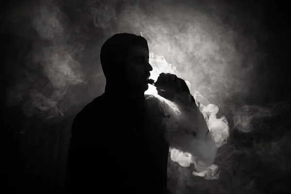 Vaping pria memegang mod. Awan Uap. Latar belakang hitam Menguap rokok elektronik dengan banyak asap. Konsep Vape — Stok Foto