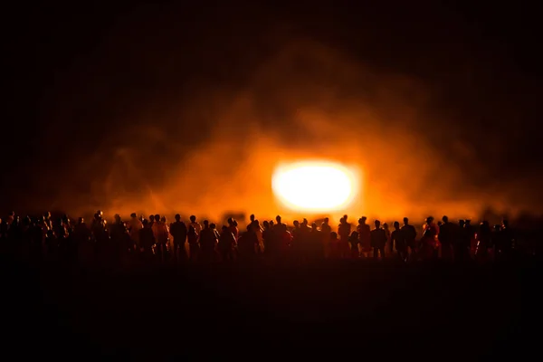 Silhuetas de uma multidão em pé no campo atrás do fundo embaçado nebuloso. Revolução, as pessoas protestam contra o governo, o homem lutando por direitos — Fotografia de Stock