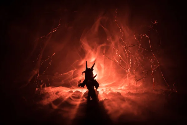 Silhouette eines feuerspeienden Drachen mit großen Flügeln auf dunkelorangefarbenem Hintergrund. Horrorbild — Stockfoto